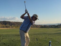 Golfer taking a swing on a scenic golf course, highlighting the experience of playing on legendary golf courses and links.