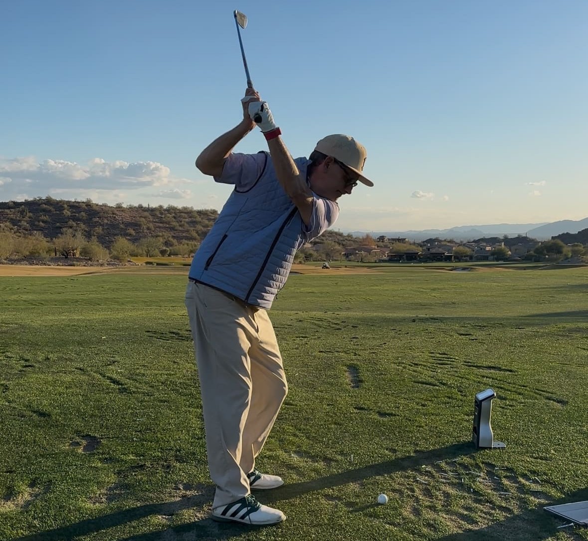 Golfer taking a swing on a scenic golf course, highlighting the experience of playing on legendary golf courses and links.